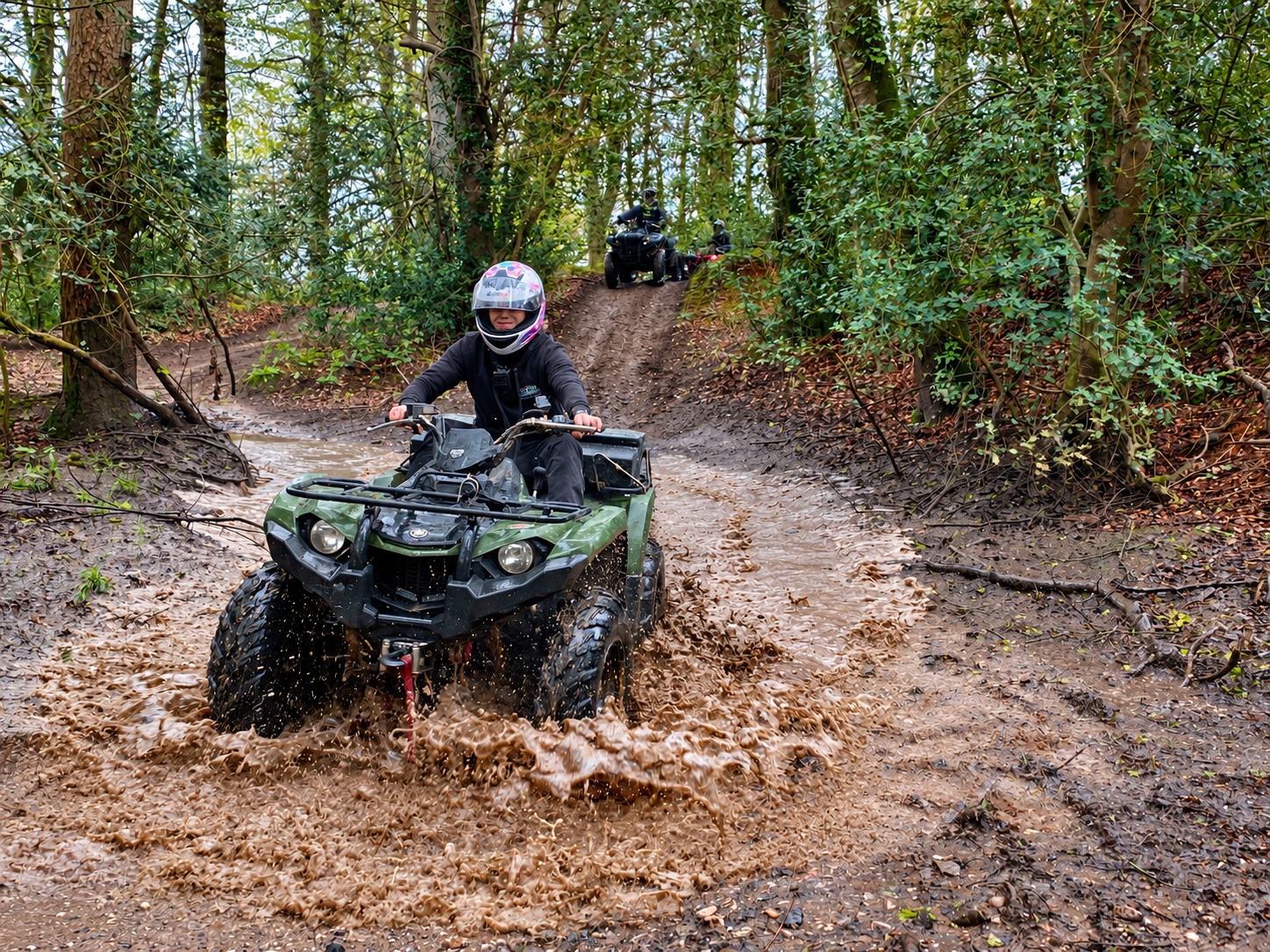 A rider splashing through a woodland puddle